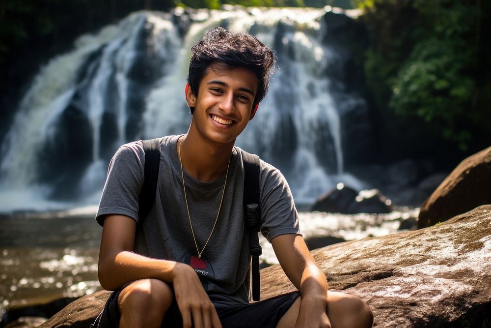 Indian teen age man waterfall portrait outdoors.
