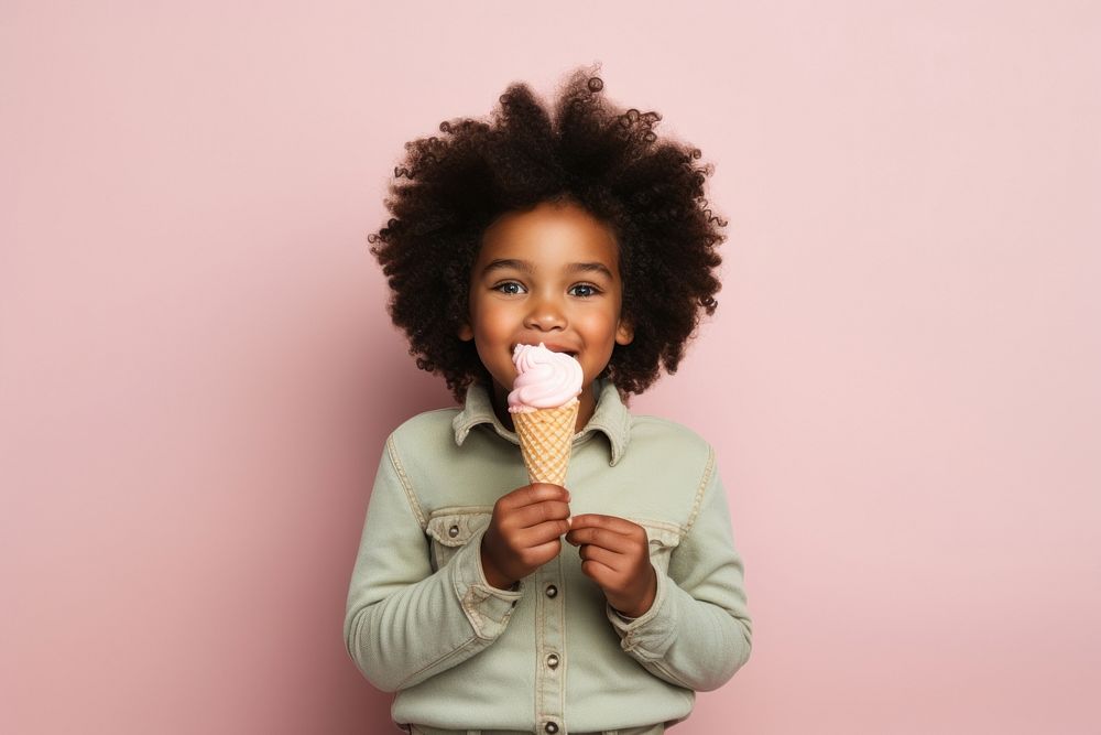 Black little girl eating child cream food.