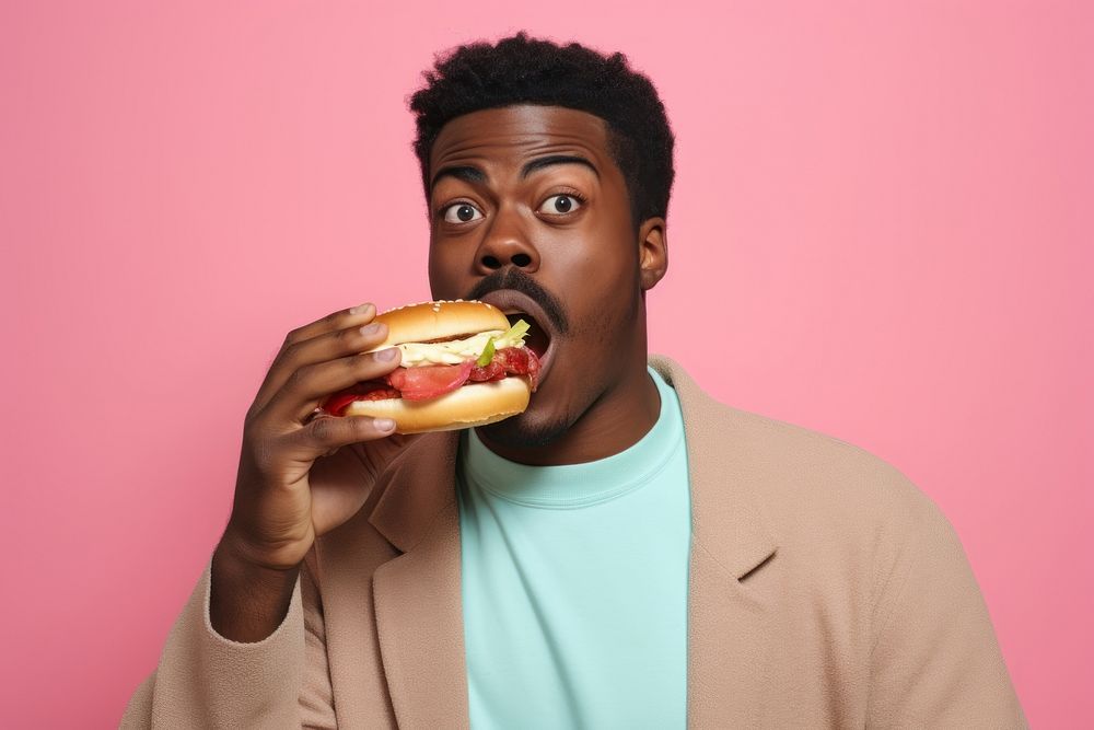Black man eating food hamburger biting.