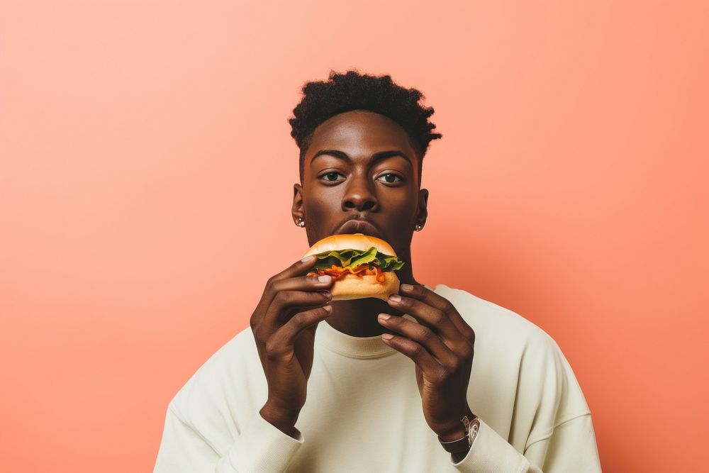 Black man eating food hamburger biting.