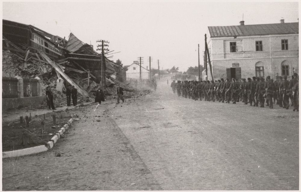 Soldaten lopen door een kapotte stad (1940 - 1945) by anonymous
