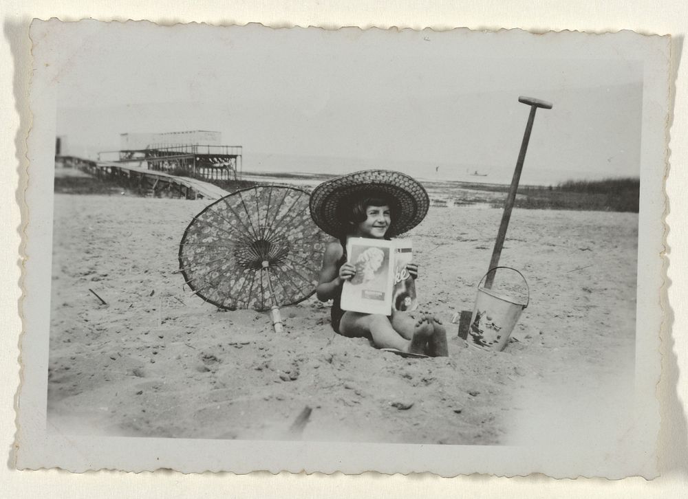 Meisje met zonnehoed zittend op het strand van Valkeveen (c. 1936) by anonymous