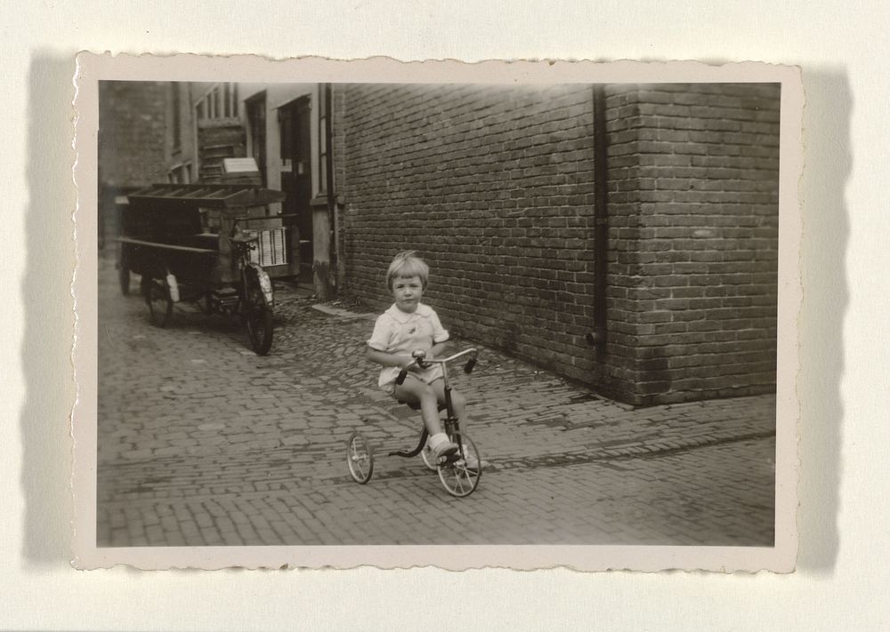 Meisje op een driewieler op straat (c. 1925 - c. 1950) by anonymous