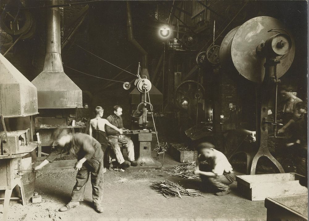 Arbeiders in een metaalbewerkingsbedrijf, waronder drie kinderen (c. 1910) by anonymous