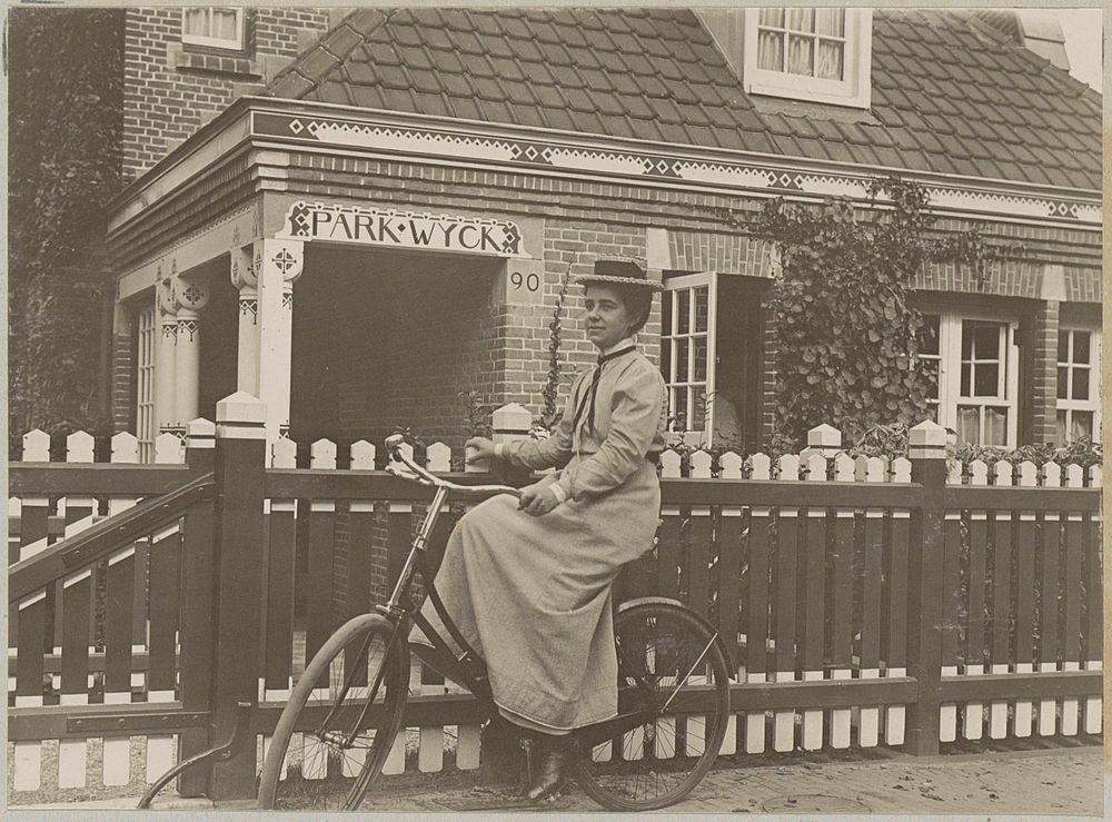 Vrouw zittend op een fiets, leunend op een tuinhek van villa Parkwijck 90 in Amsterdam (in or after 1900 - before 1914) by…