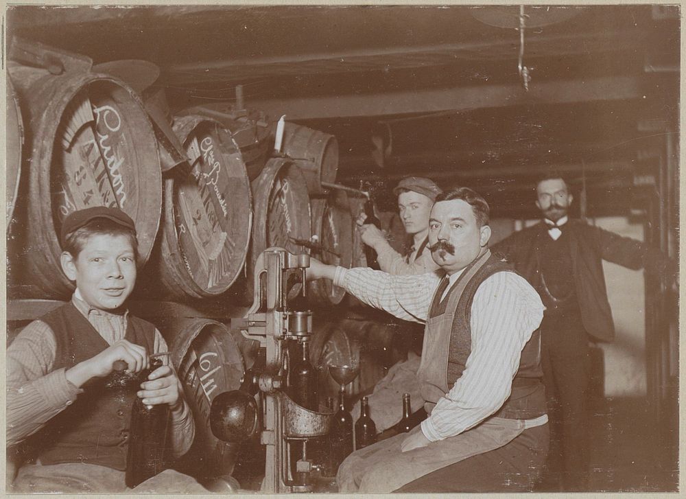 Brouwer en bedienden bij wijnvaten en een kurkmachine (c. 1900 - c. 1910) by anonymous