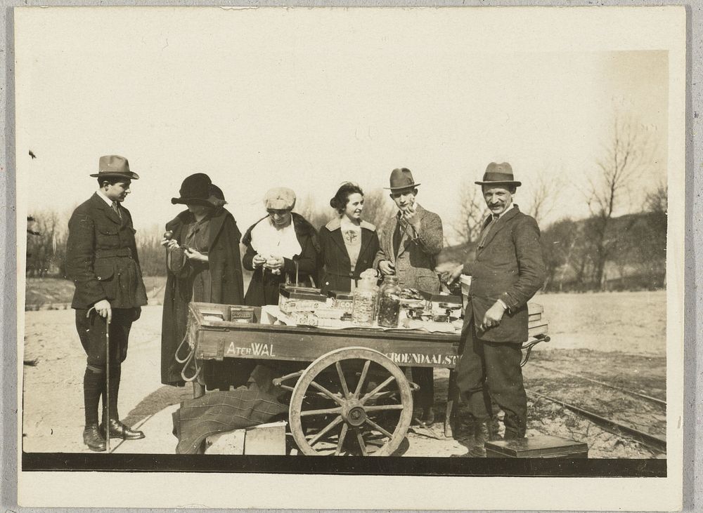 Reizende koopman met handkar en enkele klanten (1910 - 1930) by anonymous