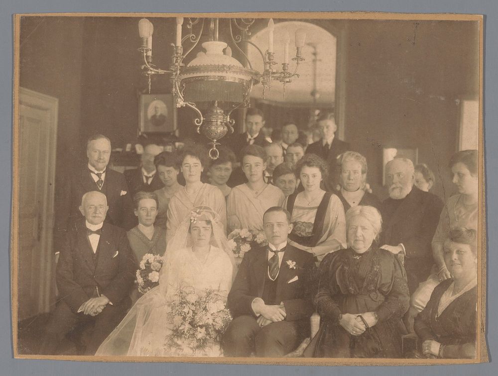 Groepsportret met op de voorgrond een onbekend bruidspaar (c. 1890 - c. 1920) by anonymous