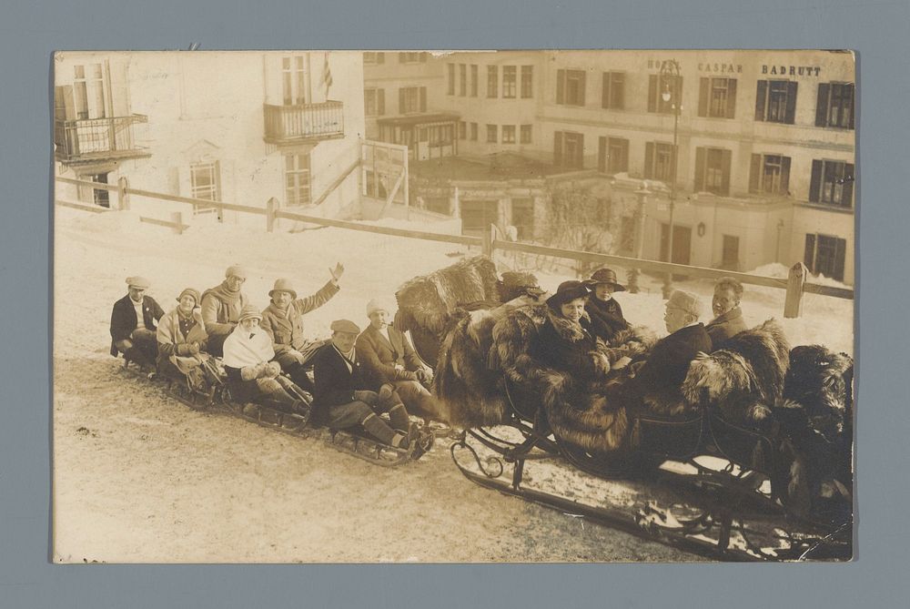 Zeven onbekende personen op houten sleeën achter een arrenslee (vermoedelijk) te Sankt Moritz (c. 1923) by anonymous