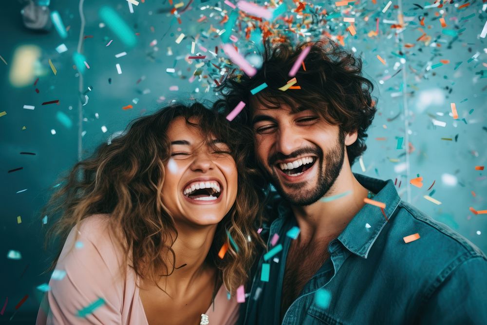 Couple having fun with confetti laughing party adult.