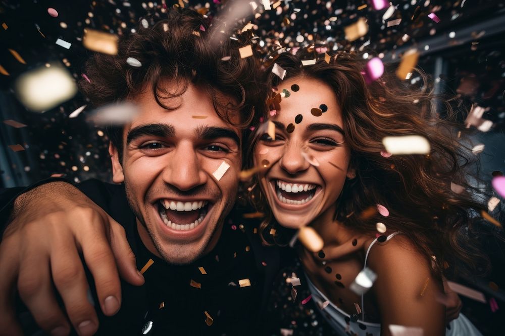 Couple having fun with confetti laughing party togetherness.