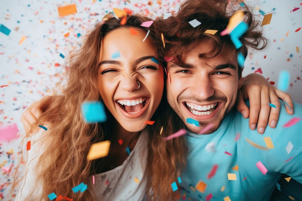 Couple having fun with confetti laughing party smile.