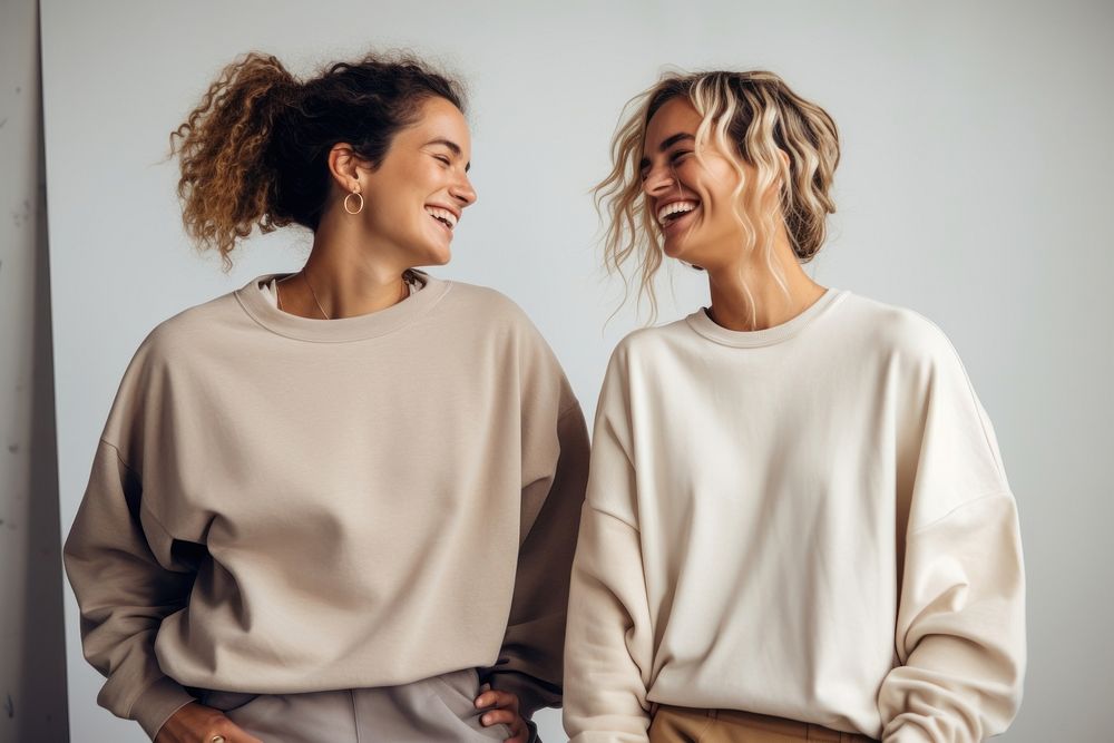 2 women wearing baggy sweatshirt laughing adult smile.