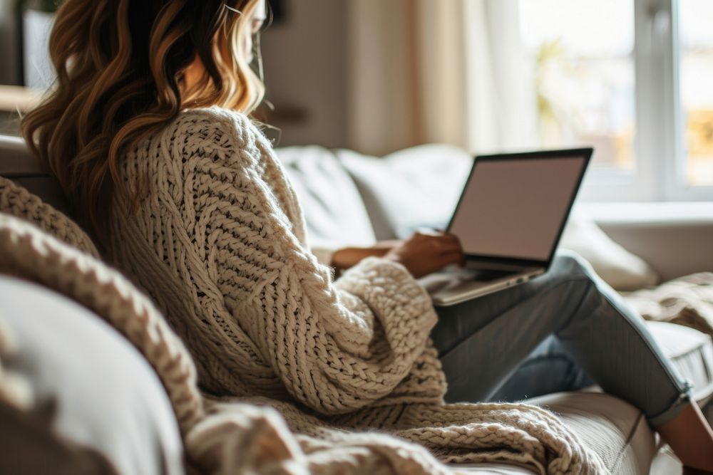 Woman using laptop computer sweater sofa. AI generated Image by rawpixel.
