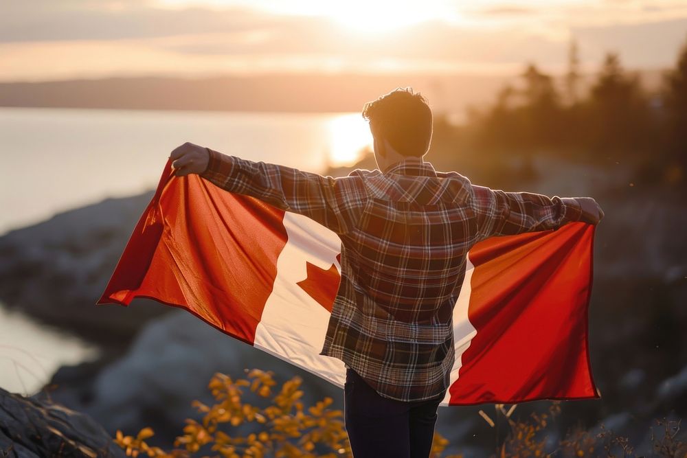 Man holding in canadian flag adult patriotism sunlight. AI generated Image by rawpixel.
