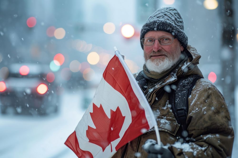 Man holding a flag of canada winter adult city. AI generated Image by rawpixel.