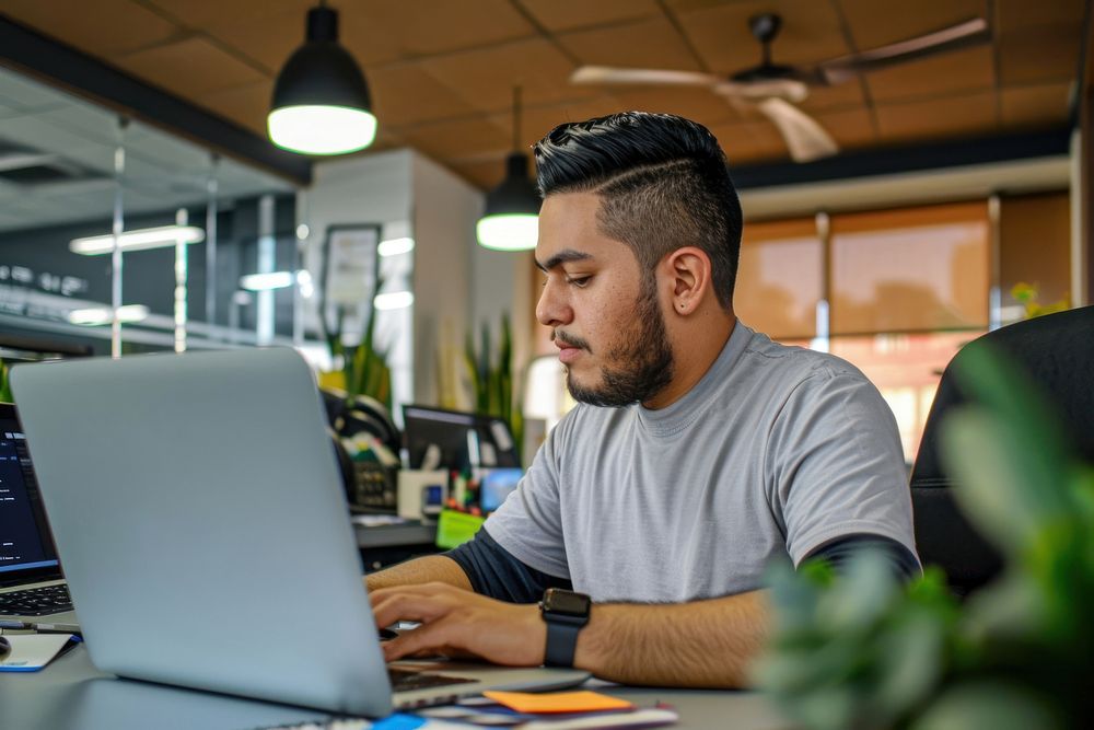 Mexican man working on a laptop computer office adult. AI generated Image by rawpixel.