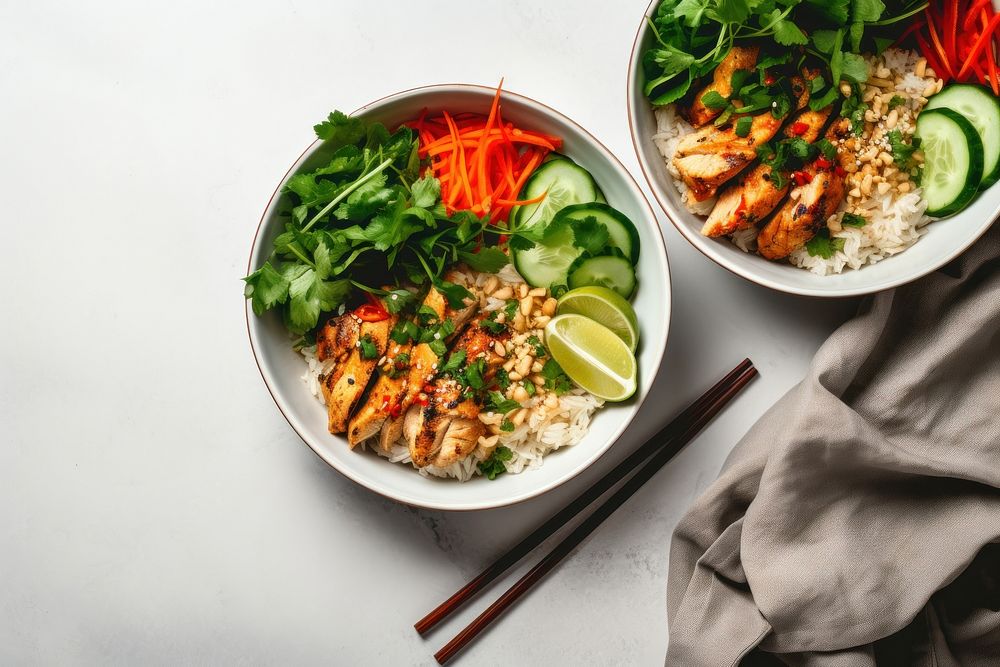 Chicken and tofu banh mi noodle bowl chopsticks plate table.