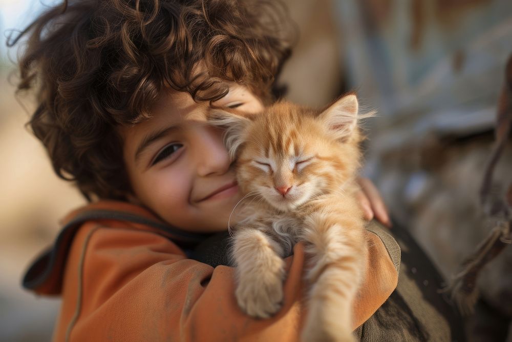 Middle eastern boy kissing his kitten portrait smiling animal.