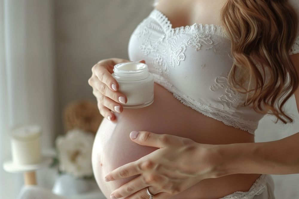 Pregnant woman applying body cream on baby bump pregnant finger hand. AI generated Image by rawpixel.