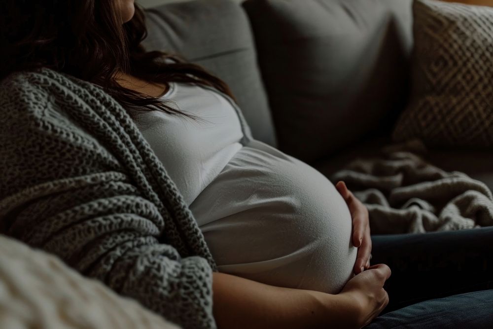 Pregnant woman lying in sofa adult anticipation beginnings. AI generated Image by rawpixel.