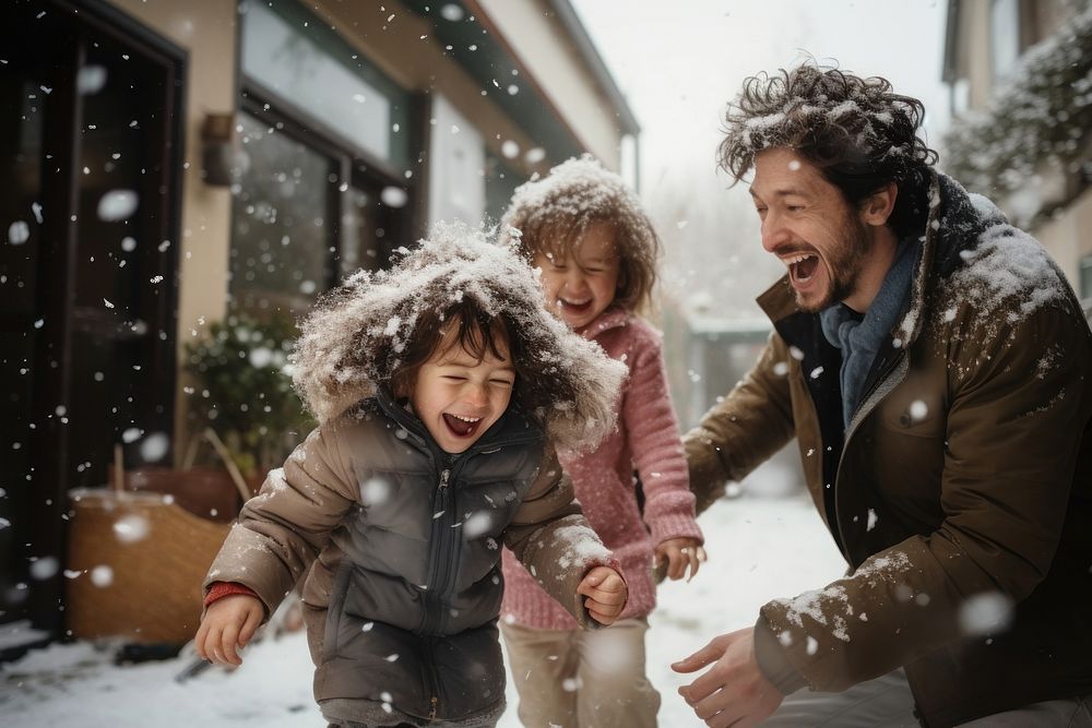 Happy family playing snow in front of home outdoors adult togetherness.