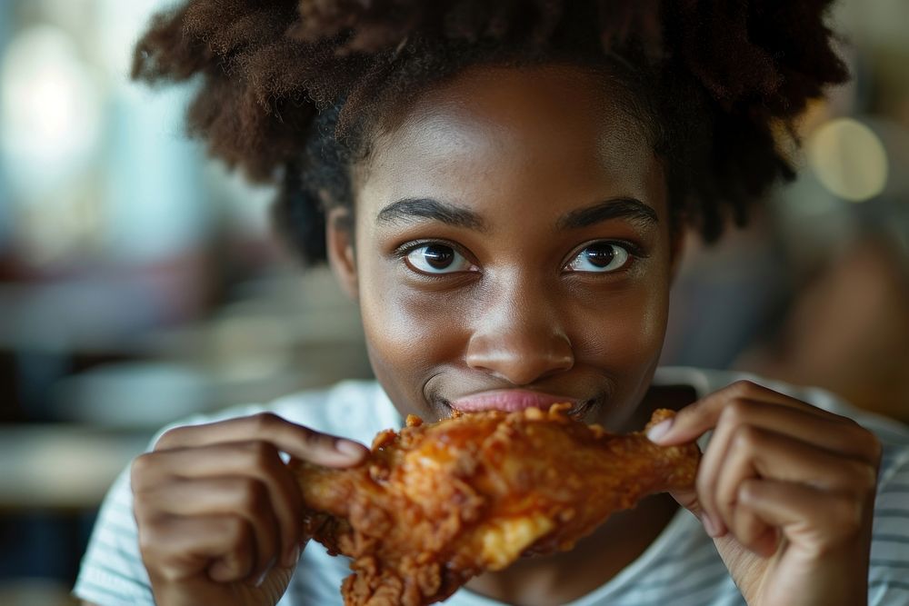 African American teenage eating biting bread.