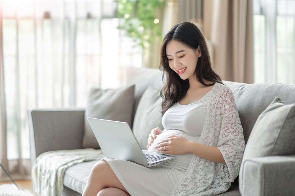 Pregnant asian woman with laptop computer sitting adult. AI generated Image by rawpixel.
