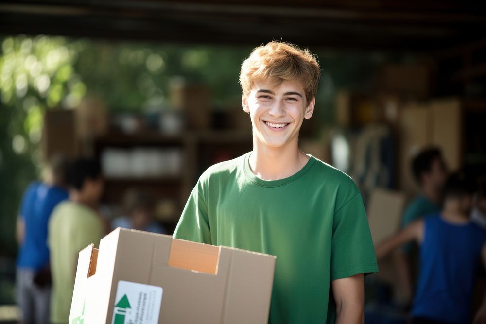 Smiling volunteer boy box cardboard carrying.