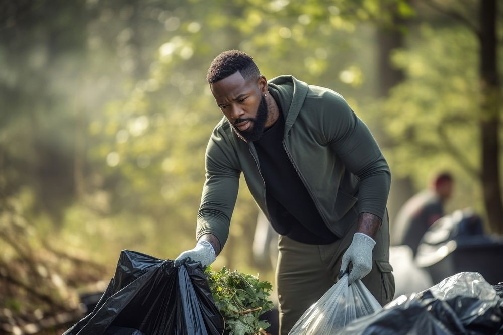 African american man volunteering outdoors garbage nature.