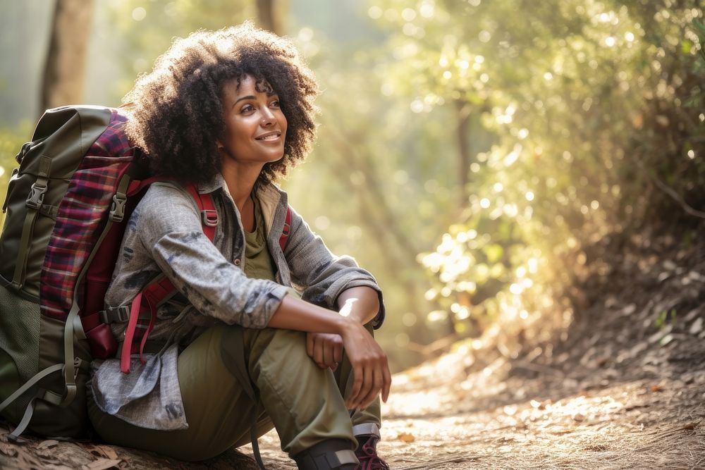 Middle age african american woman backpacker sitting forest travel.