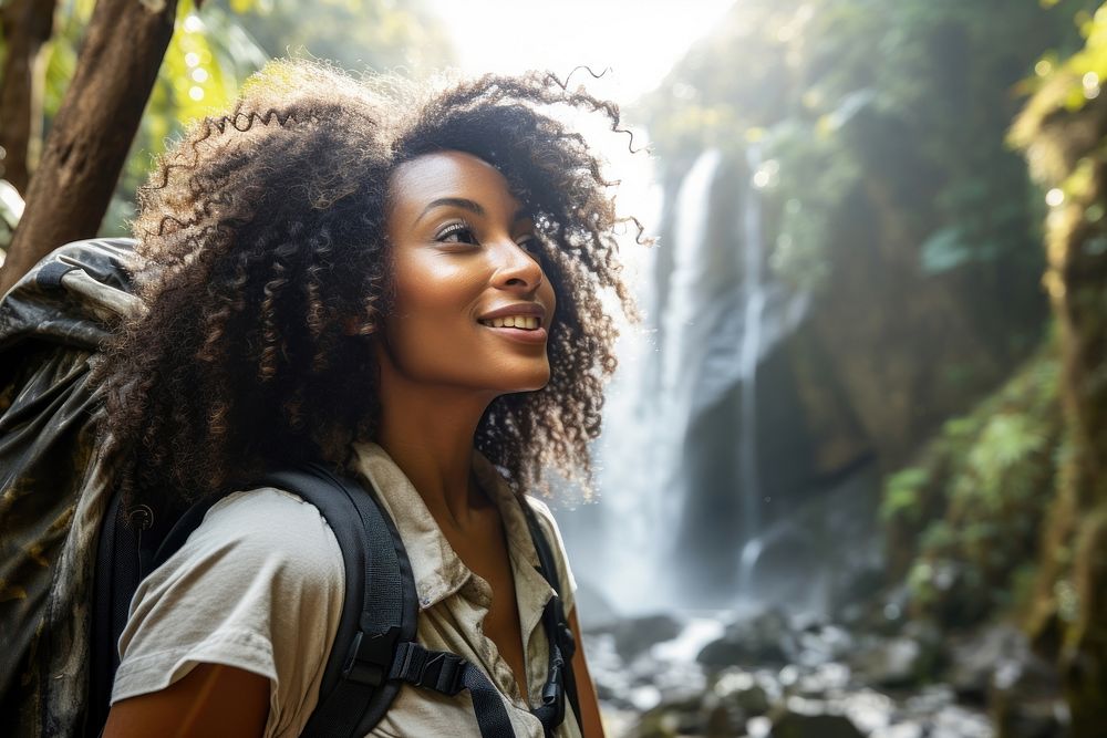 Middle age african american woman backpacker waterfall travel smile.
