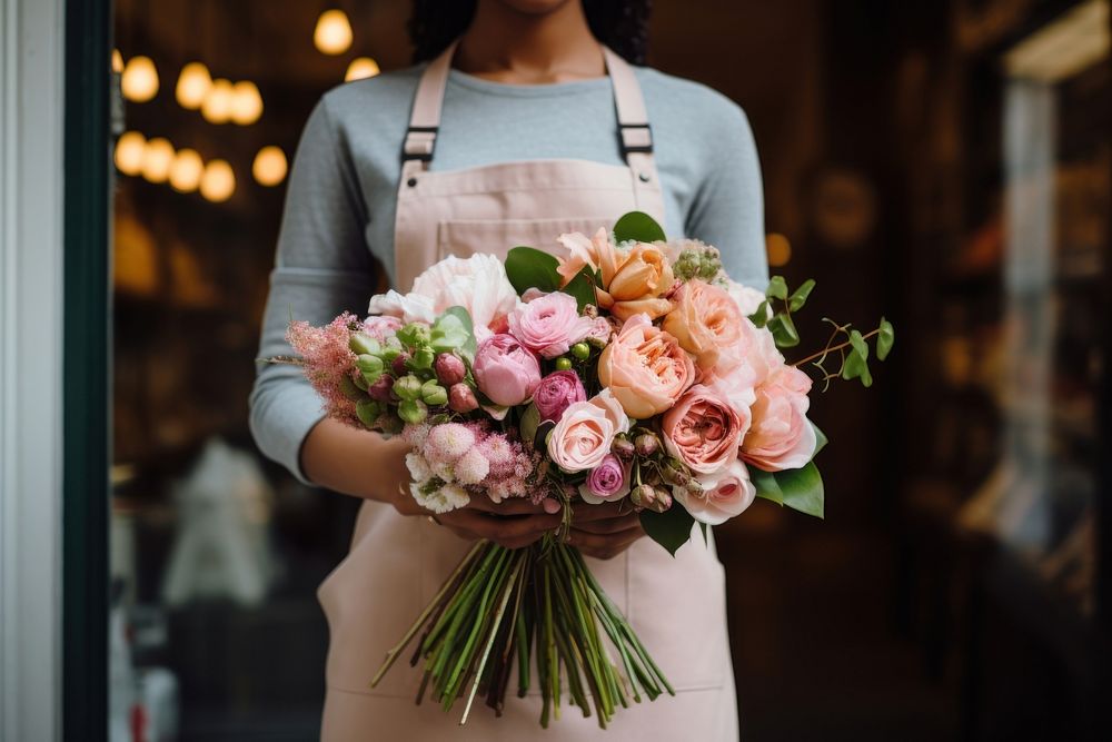 Woman in apron holding a bouquet of flowers plant store adult.