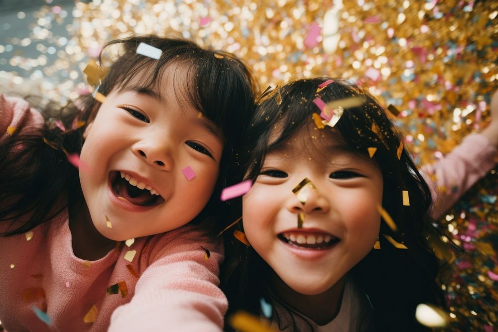 Asian kids having fun with confetti laughing portrait smile.
