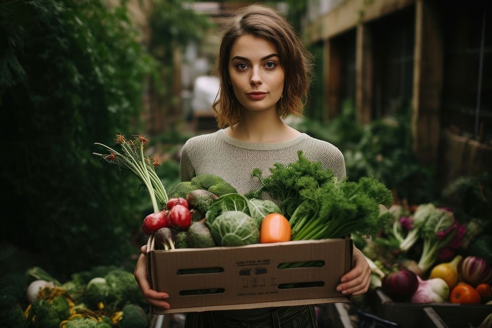 Young woman carrying a box with vegetables portrait garden adult.