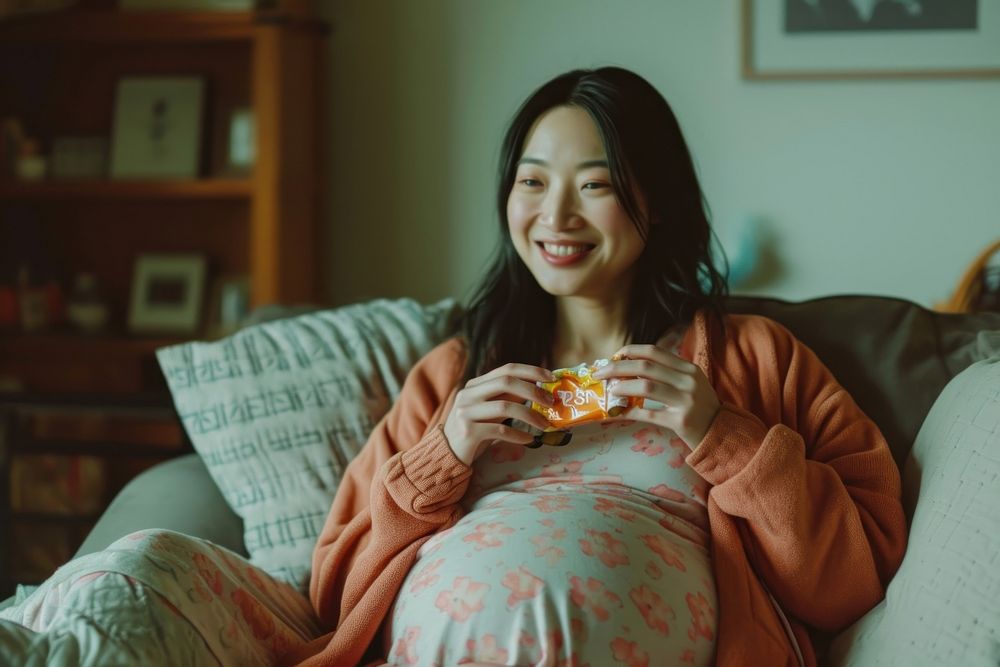 Pregnant asian woman furniture smiling sitting.