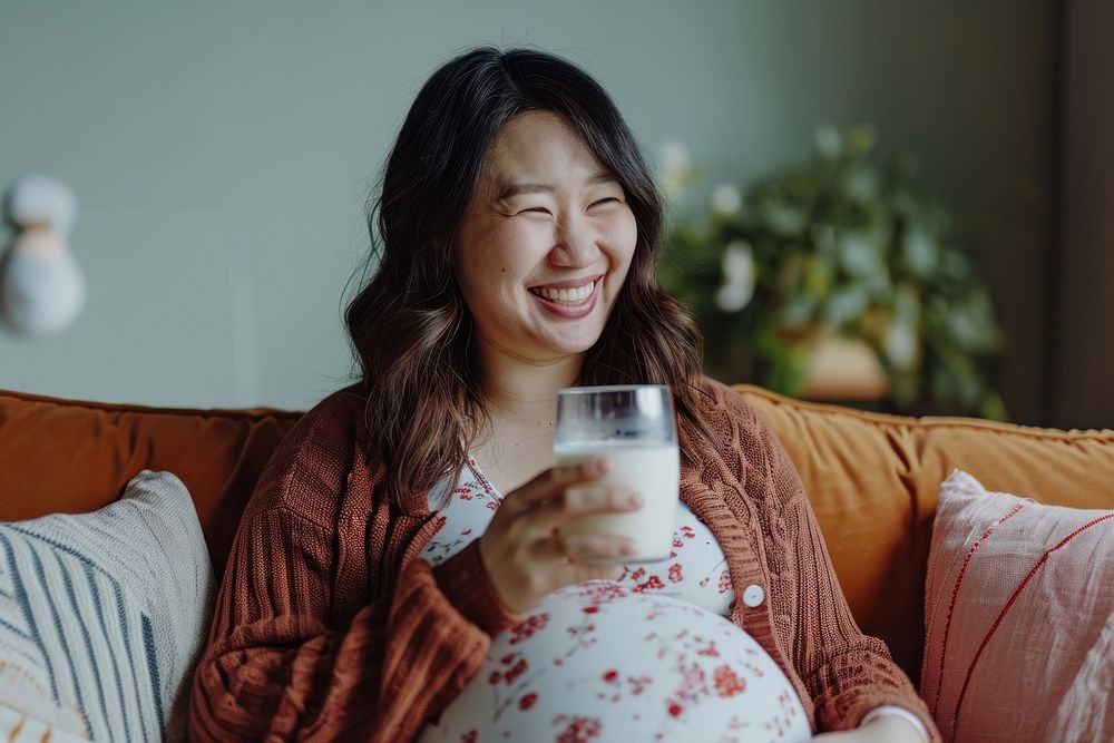 Pregnant asian woman drink drinking laughing.