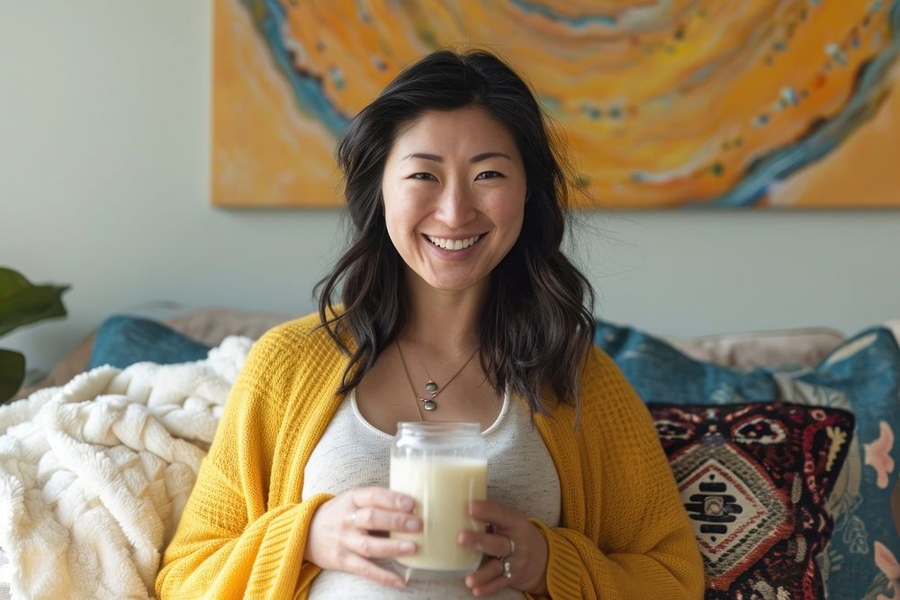 Pregnant asian woman milk drinking smiling.