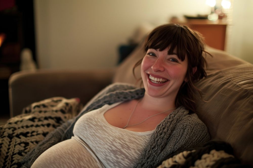 Pregnant british woman furniture laughing portrait.