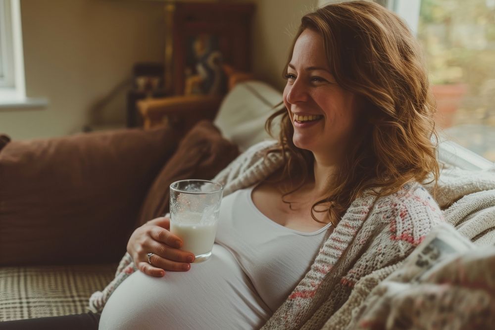 Pregnant british woman drink drinking smiling.