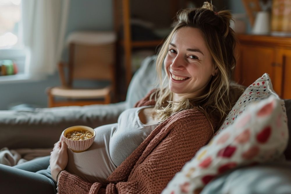 Pregnant british woman blanket smiling sitting.