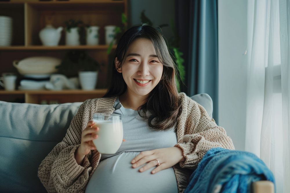 Pregnant korean woman milk drinking smiling.