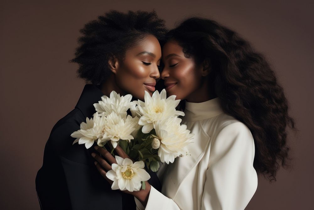 A black woman holding flower bonquet hugging another woman portrait wedding adult.