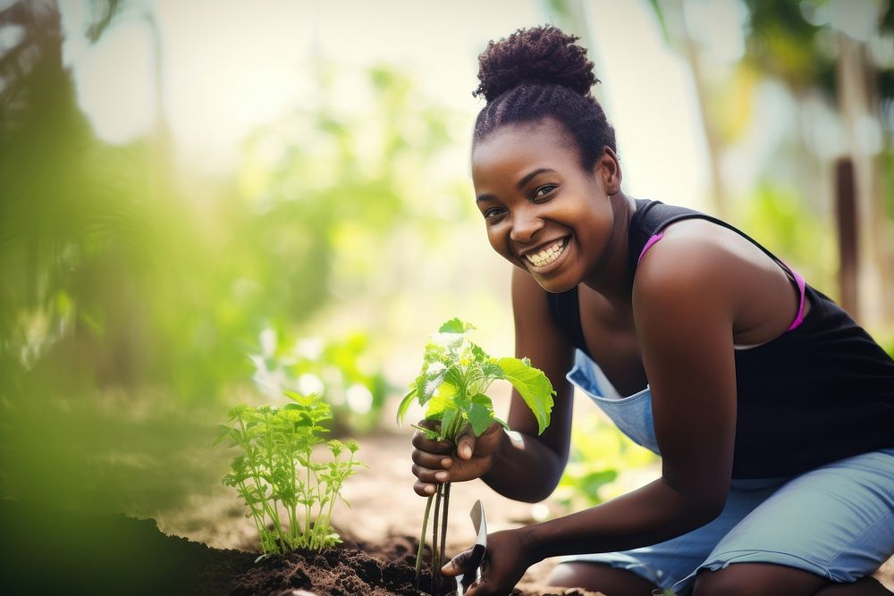 Black woman planting garden gardening outdoors.