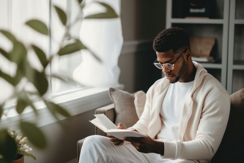 A black young man reading a book sitting adult concentration.