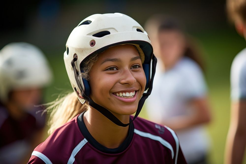 A woman wearing a rugby helmet football activity smiling.
