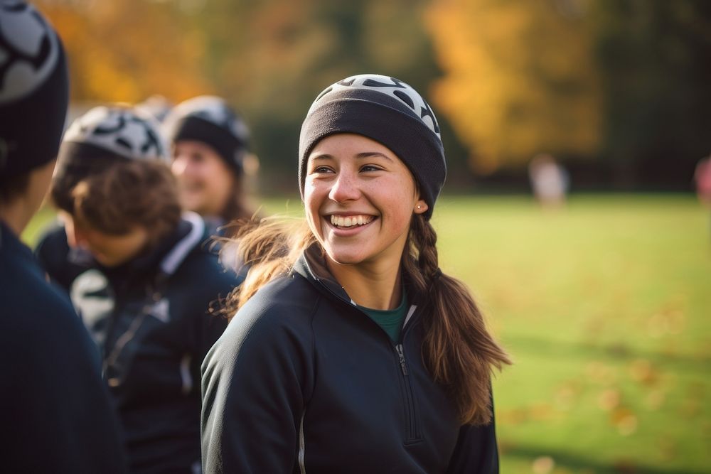 A woman wearing a soft rugby scrum cap activity portrait smiling.