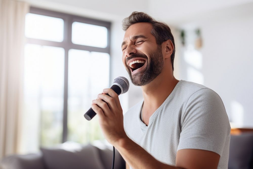 A man holding microphone singing laughing karaoke person.