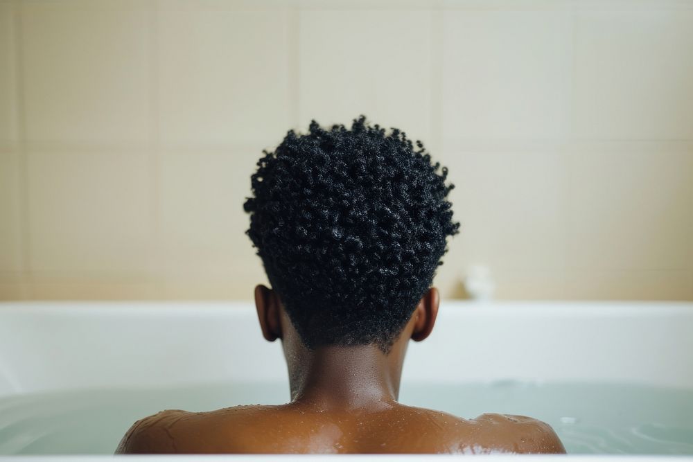 Photo of black person in large tub bathtub back hairstyle.