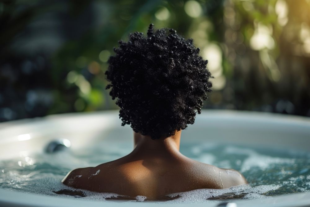 Photo of black person in large tub jacuzzi adult back.